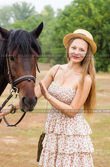 Beautiful girl in a straw hat and summer dress posing with a horse / Photo taken in Russia, at the hippodrome of the city of Orenburg. Стоковое фото, фотограф Вадим Орлов / Фотобанк Лори