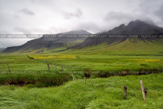 Beautiful landscape of Icelandic field with fence and mountain. Стоковое фото, фотограф Luis Louro / PantherMedia / Фотобанк Лори