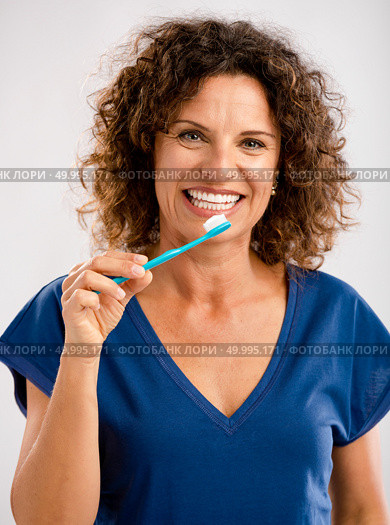 Beautiful mature woman brushing her teeths . Стоковое фото, агентство Ingram Publishing / Фотобанк Лори