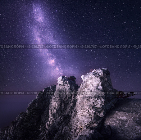 Beautiful night landscape with rocks and starry sky on the background of purple Milky Way, Magic Universe, mountains. Стоковое фото, агентство Ingram Publishing / Фотобанк Лори