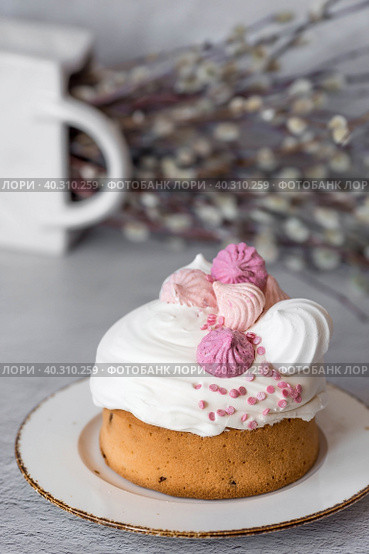 Beautiful stylish still life. Easter cake with meringue, marshmallows, Easter eggs and willow twigs on a light concrete background. happy Easter. Стоковое фото, фотограф Photojuli / Фотобанк Лори