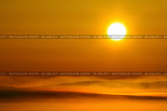 Beautiful sunrise over the tundra. Early morning in May. Over the Anadyr estuary clubs of fog rise. The large disk of the sun colors the atmosphere in golden color. Chukotka, the Far East of Russia. Стоковое фото, фотограф Андрей Степанов / Фотобанк Лори