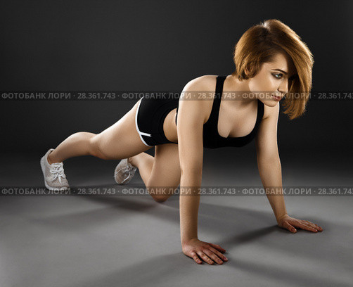 beautiful young woman doing push-ups on a dark background. Стоковое фото, фотограф Restyler Viacheslav / Фотобанк Лори