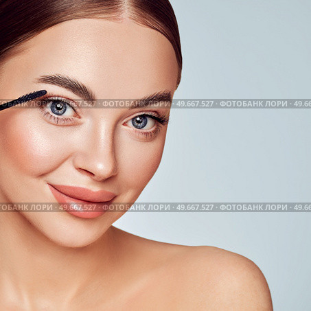Beauty woman applying black mascara on eyelashes with makeup brush. Eyelash extensions. makeup, cosmetics. beauty, skincare. Стоковое фото, агентство Ingram Publishing / Фотобанк Лори