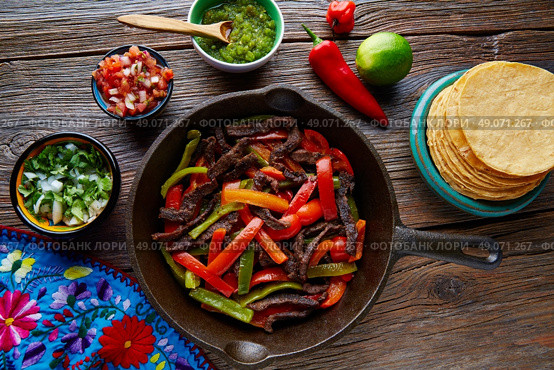 Beef fajitas in a pan with sauces chili and sides Mexican food. Стоковое фото, агентство Ingram Publishing / Фотобанк Лори