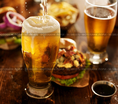 beer being poured into glass with gourmet hamburgers. Стоковое фото, агентство Ingram Publishing / Фотобанк Лори