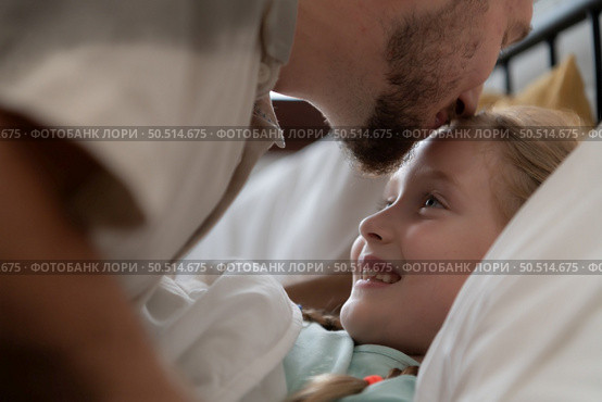 Before retiring to night, a father expresses his affection by kissing his daughter on the forehead. to get a good night’s rest. Стоковое фото, агентство Ingram Publishing / Фотобанк Лори