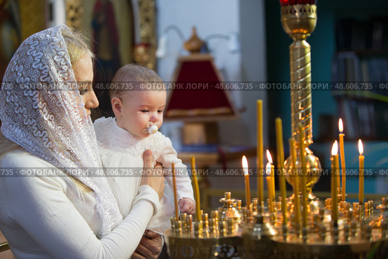 Belarus, Gomel, 25 March. 2018. The Prudhkovsky Church.The mother holds the child on her hands during the rite of baptism.Accept religion. Редакционное фото, фотограф Лазаренко Светлана / Фотобанк Лори