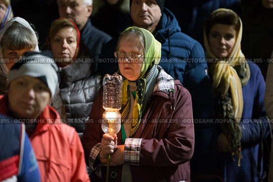Belarus, Gomel, 8 April 2018. The Nikolsky Monastery. The celebration of Orthodox Easter. Grandmother with a candle in the church. Редакционное фото, фотограф Лазаренко Светлана / Фотобанк Лори