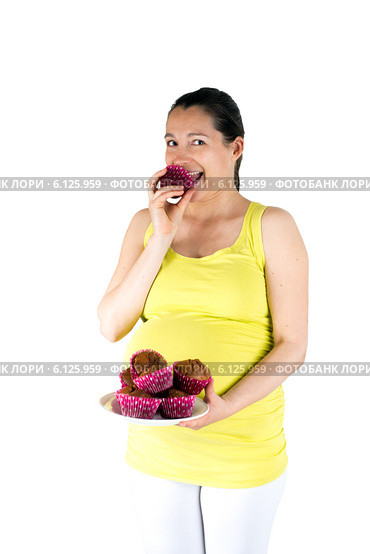 Беременная женщина ест сладкие кексы. Pregnant woman eating muffins. Стоковое фото, фотограф Сергей Левыкин / Фотобанк Лори