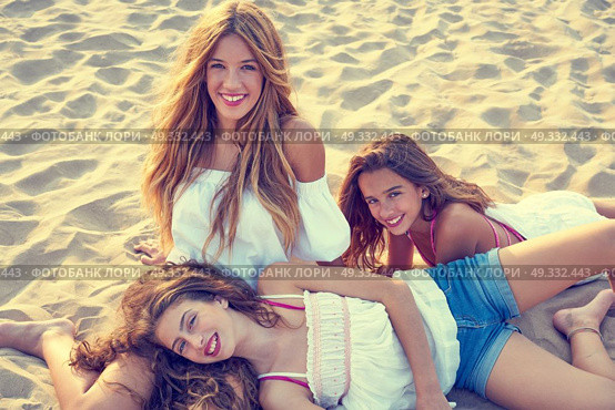 Best friends teen girls together relaxed on a beach sand at sunset. Стоковое фото, агентство Ingram Publishing / Фотобанк Лори