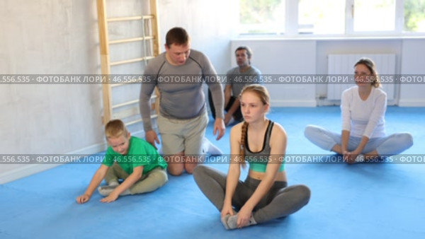 Big family before training martial arts performs stretching butterfly. Стоковое видео, видеограф Яков Филимонов / Фотобанк Лори