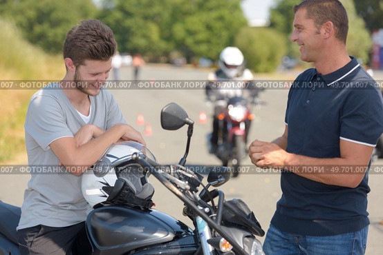 biker and young learning with motorcycle. Стоковое фото, агентство Ingram Publishing / Фотобанк Лори