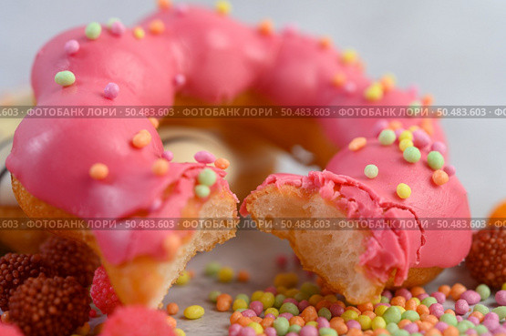 Bitten strawberry donut  decorated icing and sprinkling on the floor. Стоковое фото, агентство Ingram Publishing / Фотобанк Лори