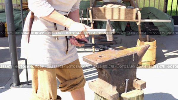 Blacksmith, metal worker. The blacksmith taps the metal with a hammer. Стоковое видео, видеограф Egor Sarantstv / Фотобанк Лори