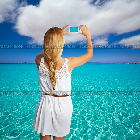 Blond braid tourist girl smartphone photo beach of Formentera photomount. Стоковое фото, агентство Ingram Publishing / Фотобанк Лори