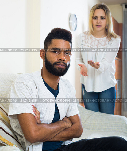 Blonde girl yelling at black boyfriend as quarreling indoors. Стоковое фото, фотограф Яков Филимонов / Фотобанк Лори