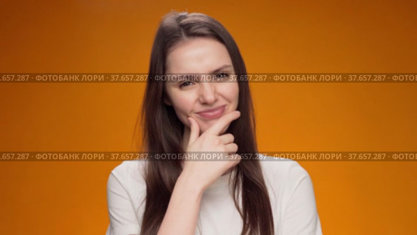 Blonde woman thinking over smart idea, pondering, against yellow background. Стоковое видео, видеограф Сергей Толмачёв / Фотобанк Лори