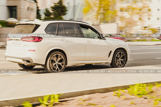 BMW X5 Fourth generation G05, car driving in city with motion blur, view from the rear side (2021 год). Редакционное фото, фотограф Константин Григорьев / Фотобанк Лори