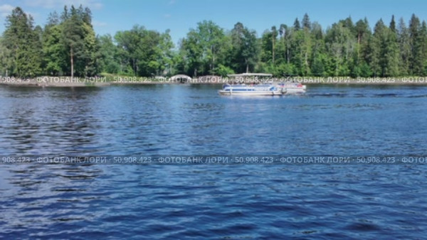 Boating and relaxation on a sunny day on the shore of the Vyborg Bay against the backdrop of green trees - Vyborg, Russia, July 15, 2025. Редакционное видео, видеограф Наталия Попова / Фотобанк Лори