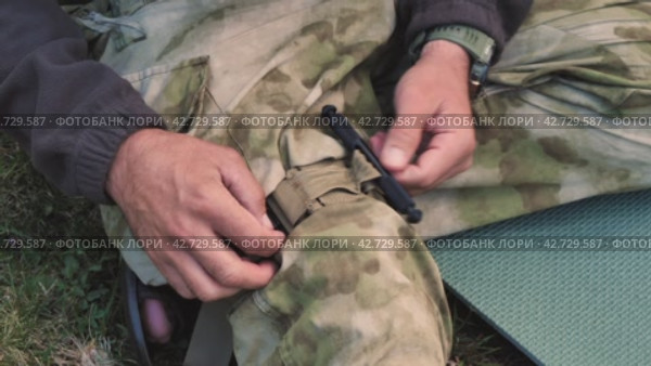Боевой медицинский жгут останавливает кровоток во время оказания первой помощи. Военный инструктор демонстрирует наложение жгута на ногу. Военная медицина. Стоковое видео, видеограф Воловодов Владимир / Фотобанк Лори