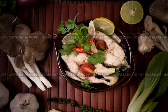 Boil the fish infusion with tomatoes, mushrooms, coriander, spring onion and lemongrass in a bowl. Стоковое фото, агентство Ingram Publishing / Фотобанк Лори