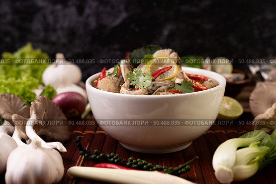 Boil the fish infusion with tomatoes, mushrooms, coriander, spring onion and lemongrass in a bowl. Стоковое фото, агентство Ingram Publishing / Фотобанк Лори
