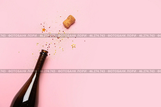 Bottle of champagne and glitters on color background. New year celebration. Стоковое фото, фотограф Pixel_shot / Фотобанк Лори