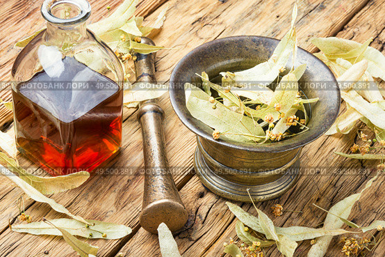 Bottle with tincture of linden flowers.Herbal medicine.Medicinal herbs and plants. Healing linden potion. Стоковое фото, агентство Ingram Publishing / Фотобанк Лори