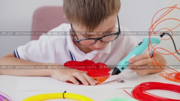 Boy drawing with 3D pen at table. Стоковое видео, видеограф Igor Skripachev / Фотобанк Лори