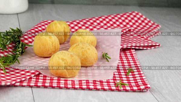 Brazilian cheese buns over red towel on wooden table. Стоковое фото, агентство Ingram Publishing / Фотобанк Лори