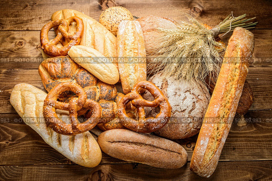 Bread, baguette, loaf and buns on the wooden desk. Bread, baguette, loaf and buns on the wooden desk. Horizontal. Стоковое фото, агентство Ingram Publishing / Фотобанк Лори
