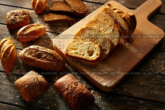 Bread varied loafs sliced on wood board in rustic wood table. Стоковое фото, агентство Ingram Publishing / Фотобанк Лори