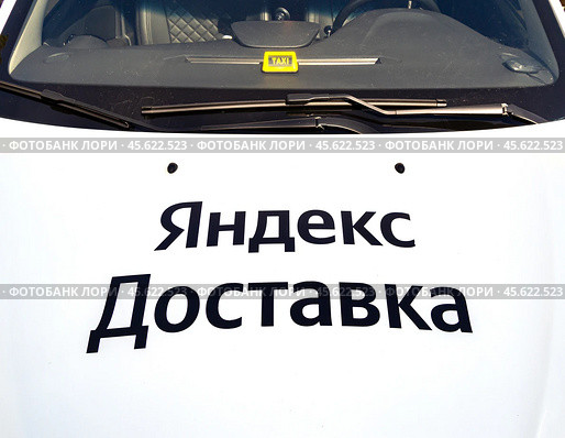 Брендирование капота автомобиля надписью сервиса "Яндекс Доставка" (2024 год). Редакционное фото, фотограф Вячеслав Палес / Фотобанк Лори