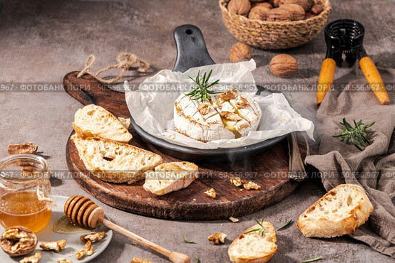 Brie type of cheese. Camembert cheese. Fresh sliced Brie cheese on a wooden tray with nuts, honey and leaves. Italian, French cheese. Стоковое фото, агентство Ingram Publishing / Фотобанк Лори