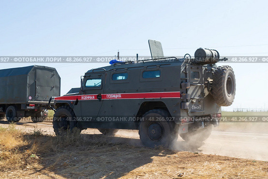 Бронированный автомобиль ГАЗ Тигр военной полиции движется по полевой дороге. Средняя Ахтуба, Волгоградская область, Россия (2021 год). Редакционное фото, фотограф Андрей Цыганков / Фотобанк Лори