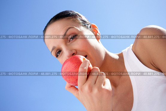 Brunette biting into red apple. Стоковое фото, агентство Ingram Publishing / Фотобанк Лори