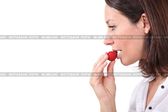 Brunette eating strawberry. Стоковое фото, агентство Ingram Publishing / Фотобанк Лори