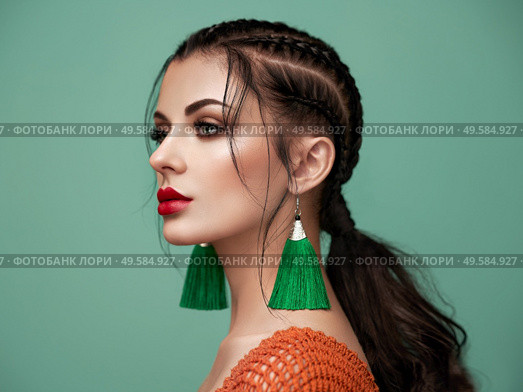 Brunette girl with perfect makeup. Beautiful model woman with curly hairstyle. Care and beauty hair products. Lady with braided hair. Model with jewelry. Turquoise background. Стоковое фото, агентство Ingram Publishing / Фотобанк Лори