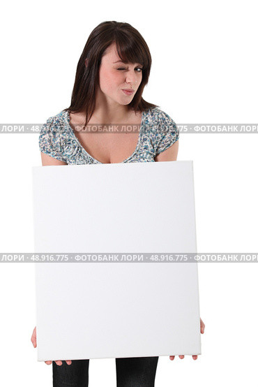 Brunette winking whilst holding advertising panel. Стоковое фото, агентство Ingram Publishing / Фотобанк Лори