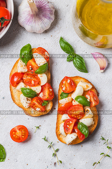 Bruschetta caprese with cherry tomatoes and mozzarella garnished with basil. Стоковое фото, фотограф Светлана Денисова / Фотобанк Лори