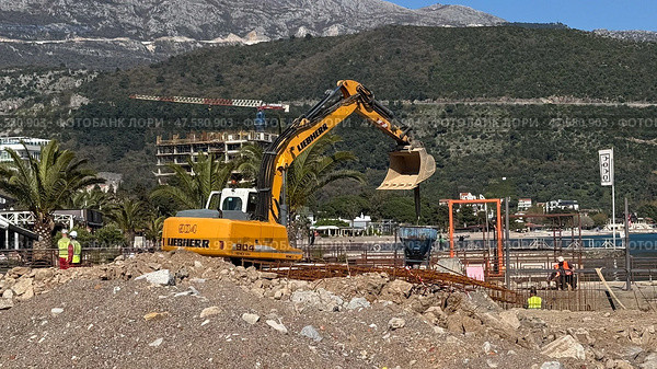 Budva,Montenegro-April 11,2025:Liebherr excavator operating at a beachside. Редакционное фото, фотограф Margarita Davchenko / Фотобанк Лори