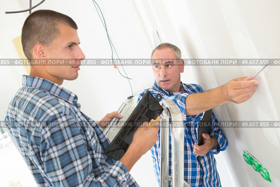 builder applies glue on a wall for a ceramic tile. Стоковое фото, агентство Ingram Publishing / Фотобанк Лори