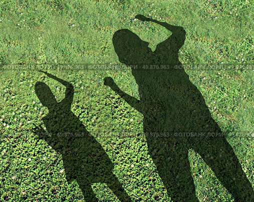 Bullying kids and school bully concept with the shadows of two children with one smaller child being threatened and abused by the older kid on green grass as a symbol of school safety from bullies. Стоковое фото, агентство Ingram Publishing / Фотобанк Лори