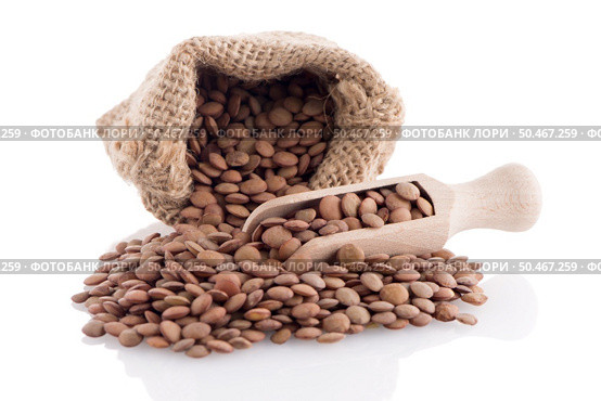 Burlap bag with lentils and wooden scoop on white background. Стоковое фото, агентство Ingram Publishing / Фотобанк Лори