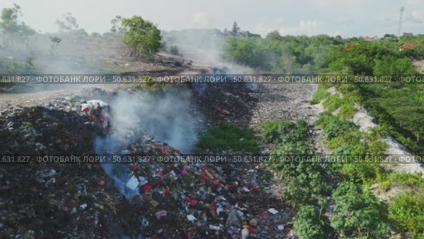 Burning trash in dump, plastic pollution, industry drone view in Bali. Стоковое видео, видеограф Wonderful nature / Фотобанк Лори