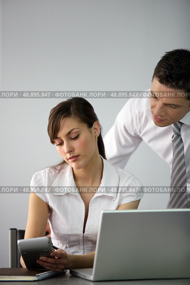 Business couple going over accounts. Стоковое фото, агентство Ingram Publishing / Фотобанк Лори