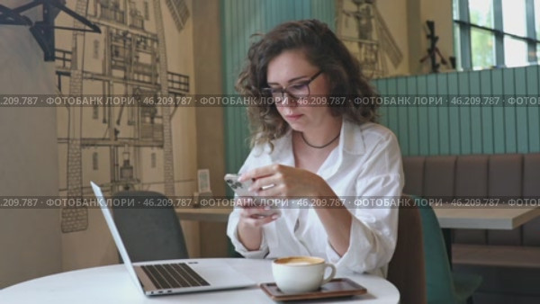 Business woman using mobile smart phone and online working on laptop computer, surfing the internet, searching the information at office. Female student online studying from home, e-learning concept. Стоковое видео, видеограф Ирина Михайличенко / Фотобанк Лори