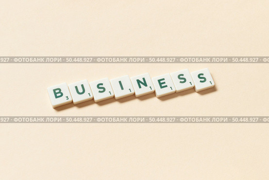 Business word formed of scrabble tiles on beige background. Minimal web design with creative lettering.. Business formed of scrabble tiles on beige background. Стоковое фото, агентство Ingram Publishing / Фотобанк Лори