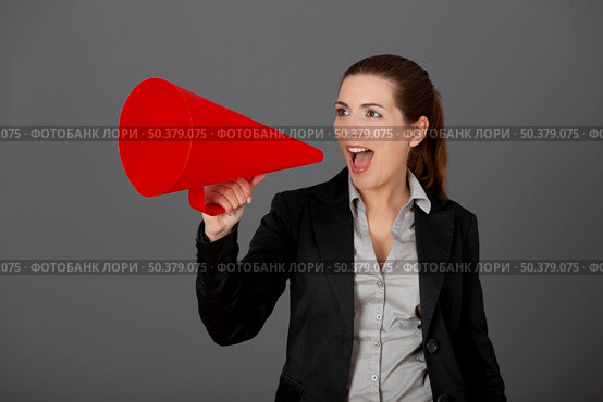 Business young woman speaking to a megaphone, over a grey background. Стоковое фото, агентство Ingram Publishing / Фотобанк Лори